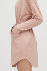 Person with hands tied at the back with a fabric belt.