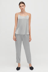 Woman standing in a casual outfit with slip-on shoes.