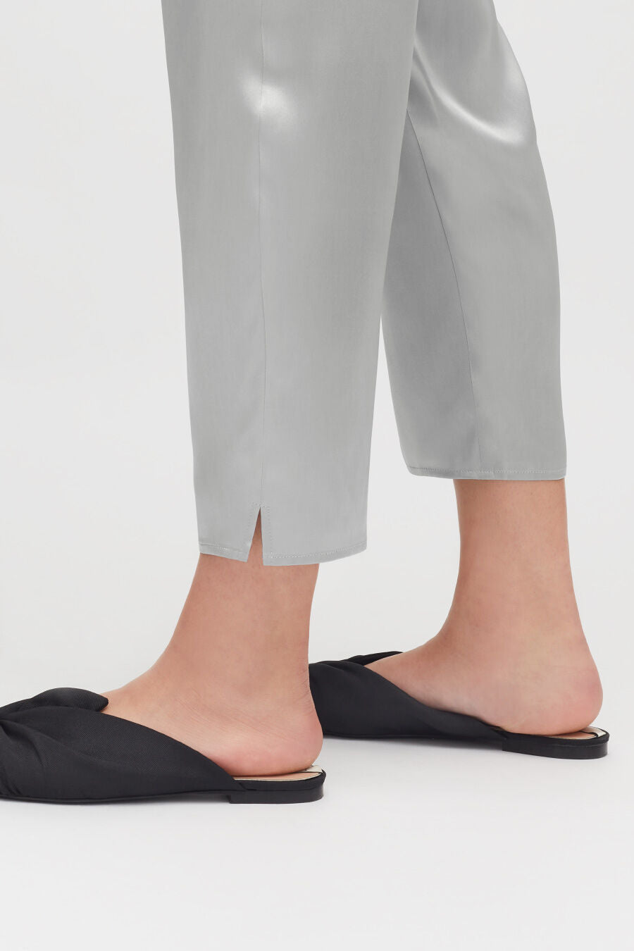 Person standing in slippers, showing only legs and feet.