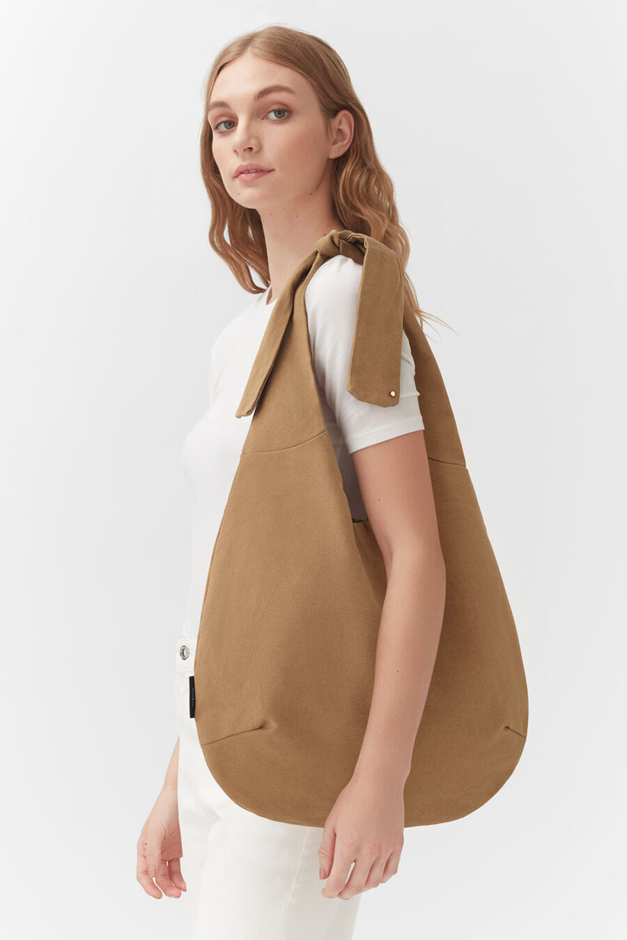 Woman standing with a large shoulder bag