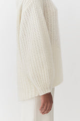 Person wearing long-sleeved top and pants, close-up view of arm and torso.