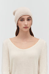 Woman wearing a beanie and sweater, looking at camera.
