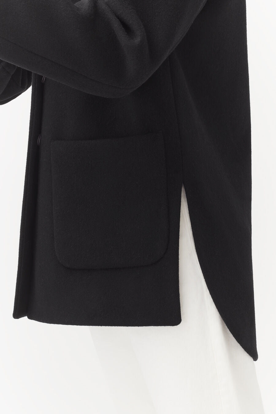 Close-up of a jacket with a pocket and draped fabric.