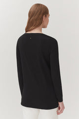 Woman in a long sleeve top viewed from the back.