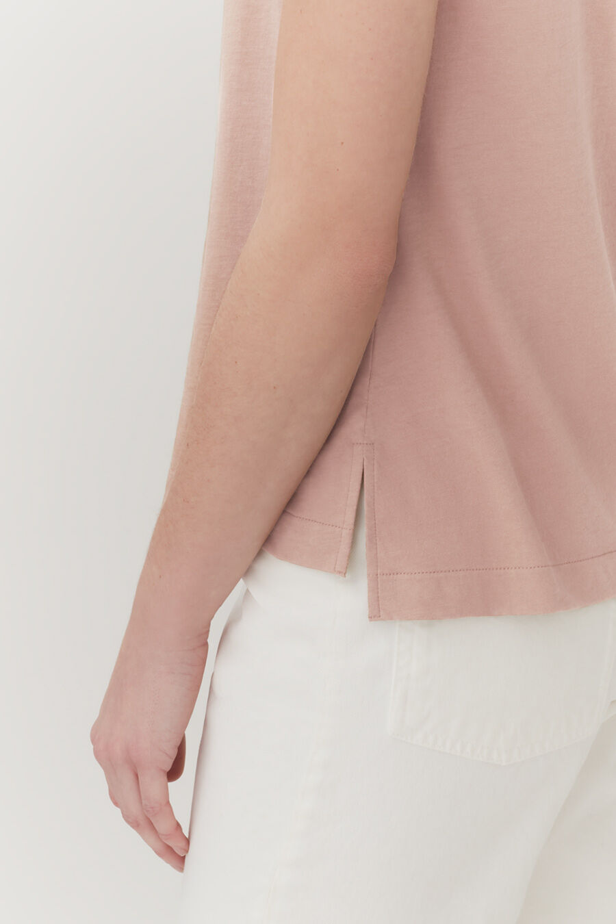 Close-up of a person's arm and torso in a casual outfit.
