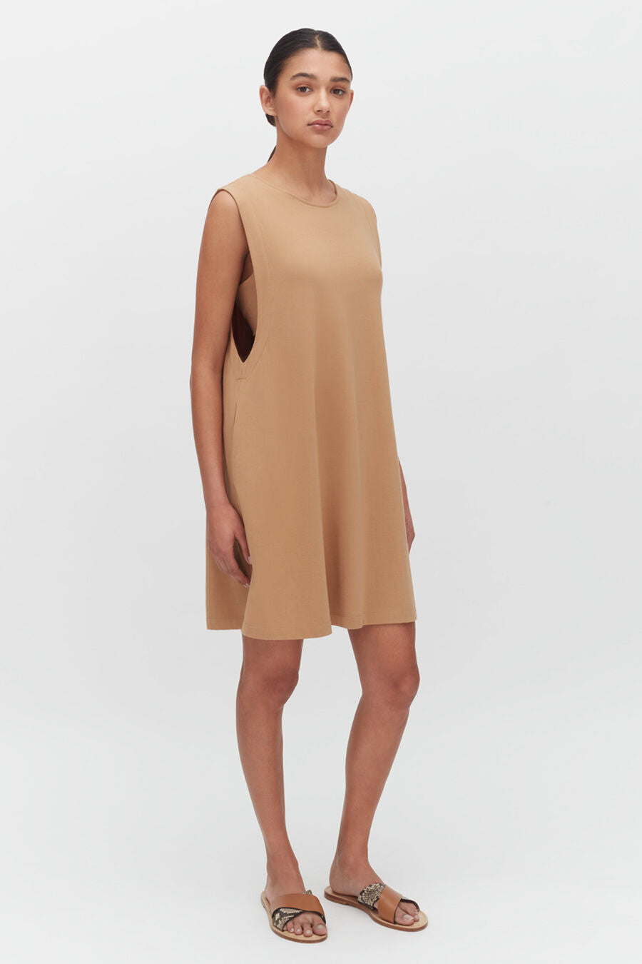 Woman standing in sleeveless dress and sandals