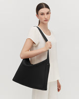 Woman standing with a large shoulder bag
