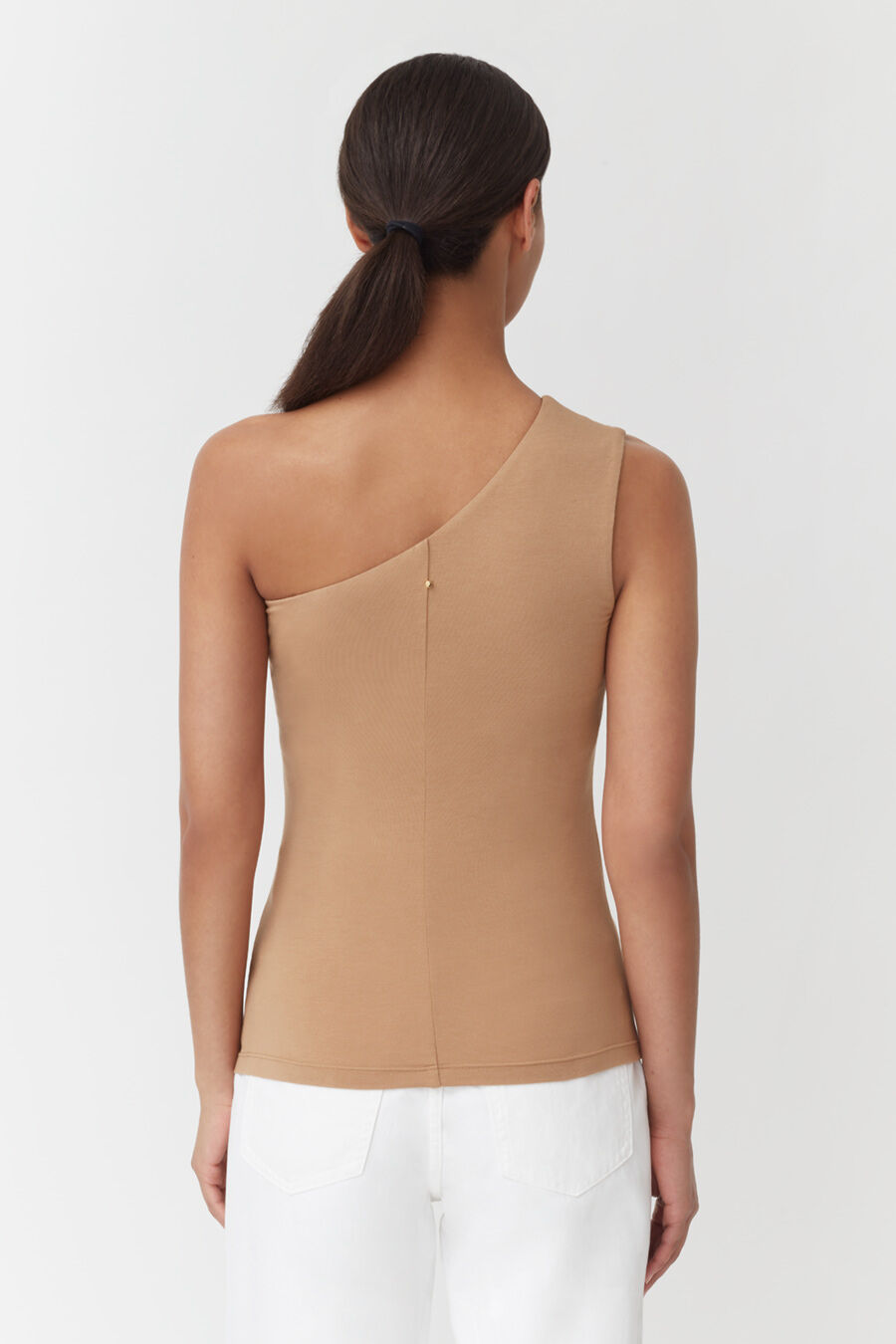 Woman from behind with ponytail, wearing a sleeveless top and pants.