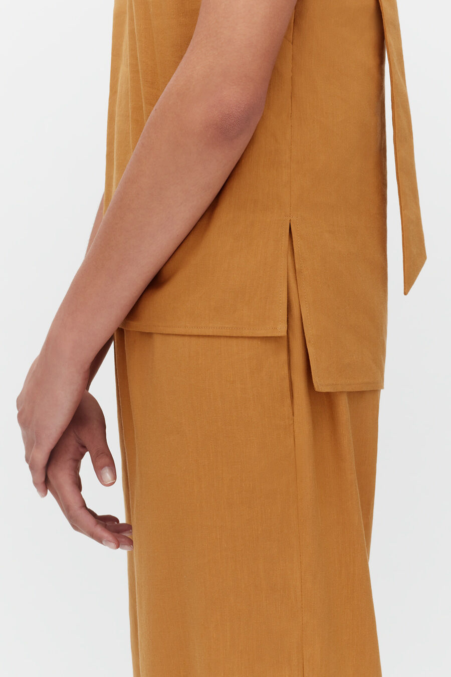 Close-up of a person's arm and side in a long-sleeve outfit with a bow detail.