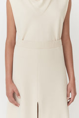 Person in a sleeveless dress with a v-neckline and frontal slit.