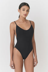 Woman standing wearing a one-piece swimsuit