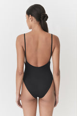 Woman in a one-piece swimsuit, viewed from the back with a hairstyle tied up.