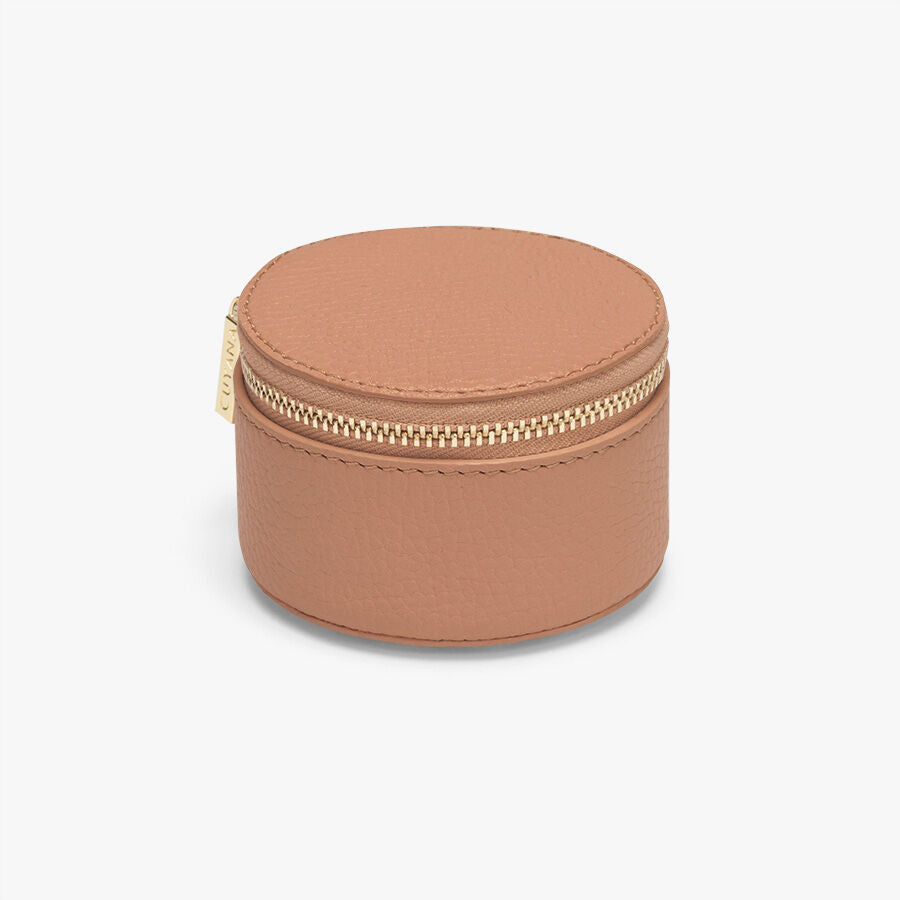 Round jewelry box with a zipper closure on a plain background.
