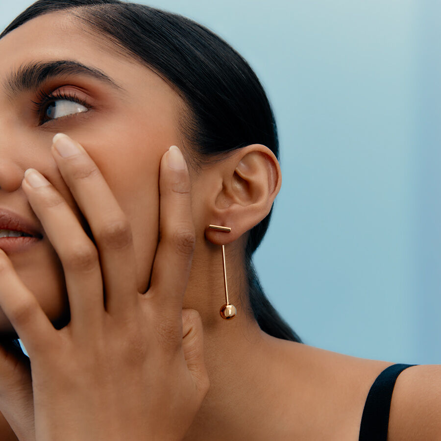 Woman touching her face while wearing an earring.