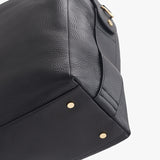 Close-up of a handbag corner with metal studs.