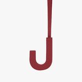 Letter J hanging by a strap against a plain background.