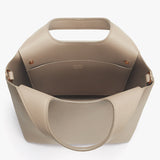 Handbag with a top handle and external pockets.
