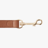Leather strap with metal clasp and brand name engraved.