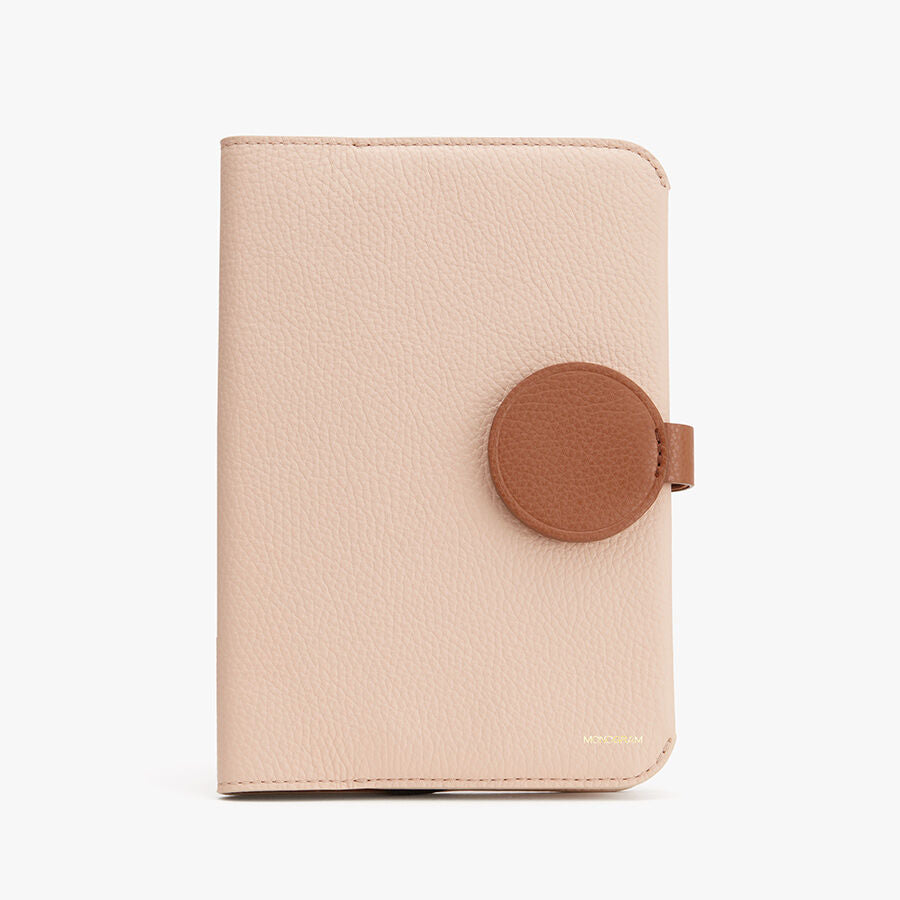 Closed wallet with circular snap closure on a plain background.