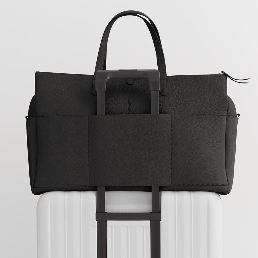Bag attached to a suitcase handle.