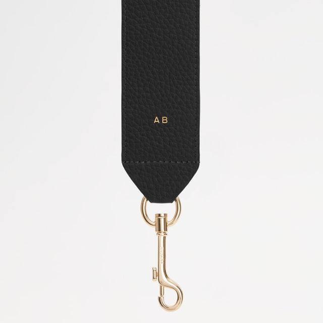 Bag strap with metal clasp and initials AB embossed.