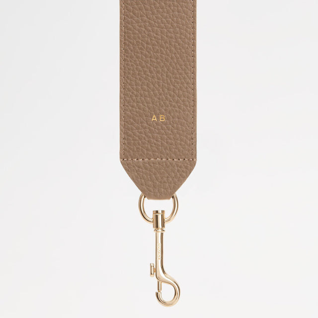 Textured strap with metal clasp and initials A.B. on it.