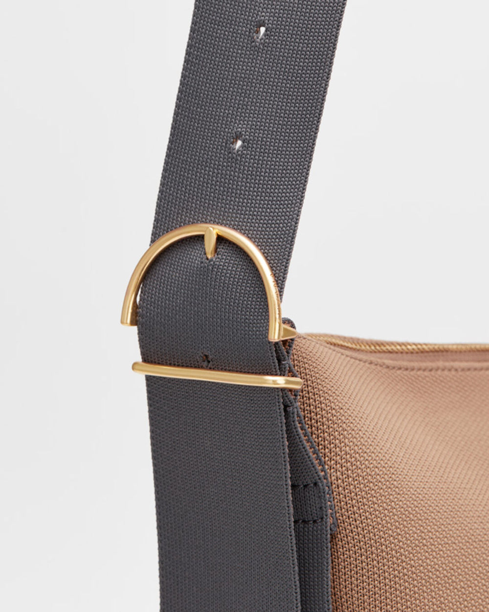 Close-up of a bag strap with a metal buckle.