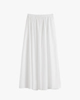 Long skirt with elastic waistband hanging against plain background.