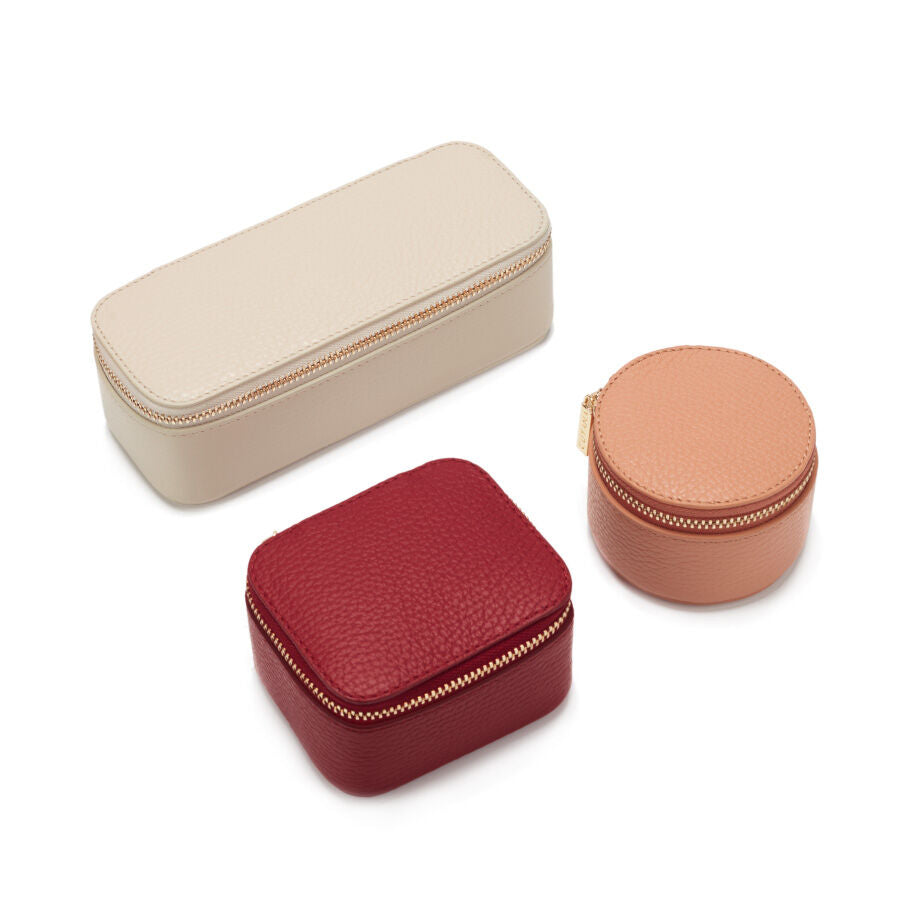 Three different-shaped small cases arranged on a plain background.