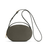 Small oval shoulder bag with a long strap and a zipper closure.