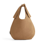 A handbag with a single loop handle, standing upright.