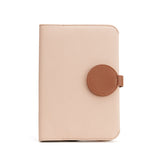 Closed wallet with circular flap closure on plain background.