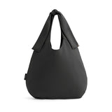 Single-handle handbag standing upright on a plain background.