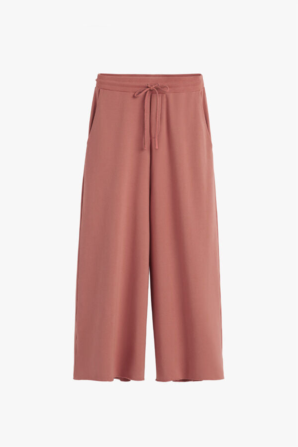 Wide-legged pants with drawstring waist, isolated on plain background.