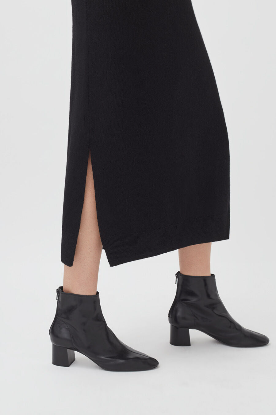 Person wearing ankle boots and a skirt with a slit.