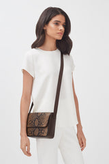 Woman in outfit carrying a shoulder bag