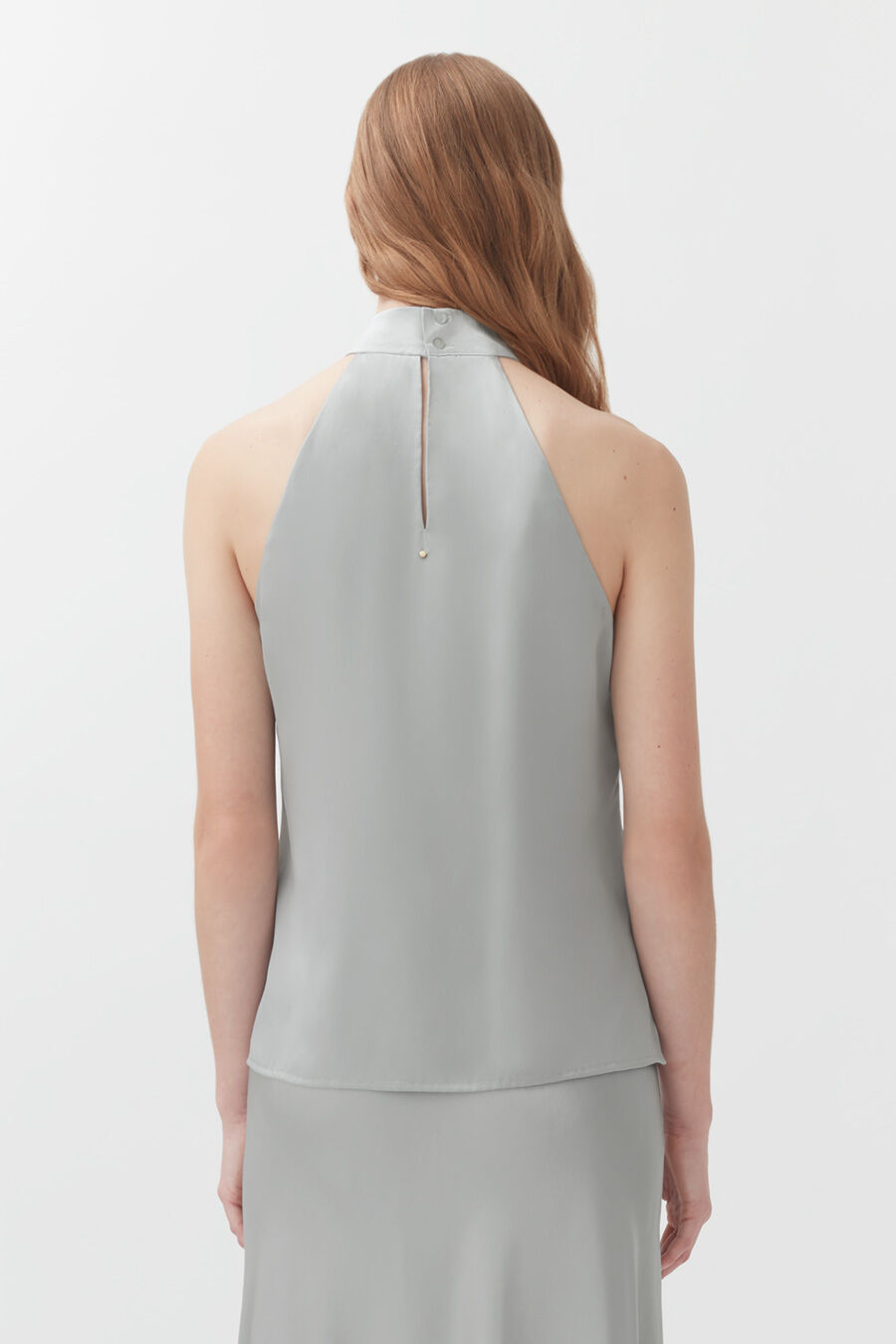 Woman facing away with hair down and an exposed back outfit with a zipper.