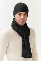 Man wearing a beanie and scarf, looking at the camera.