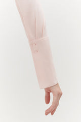 Arm in a long sleeve with two visible buttons, hand partially visible.
