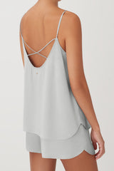 Woman from the back wearing thin strapped top and shorts.