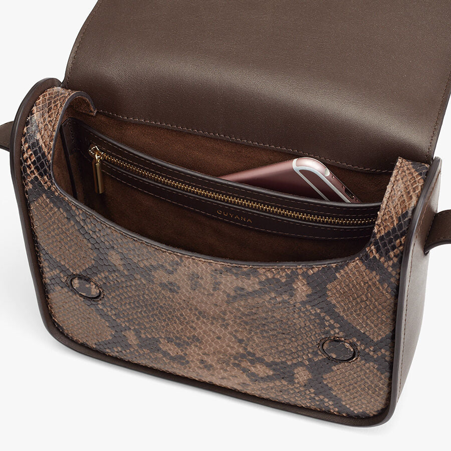 Open handbag with a phone and compartment inside.