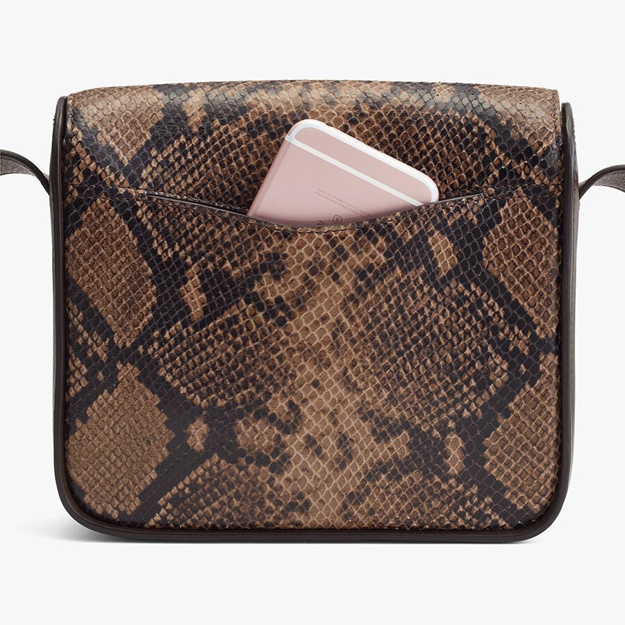 Smartphone peeking out of a patterned shoulder bag.