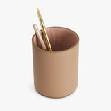Pen holder with pens on a plain background