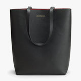 Textured tote bag with brand label and handles on top.