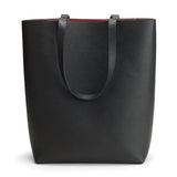 Black tote bag with upright handles on a plain background.