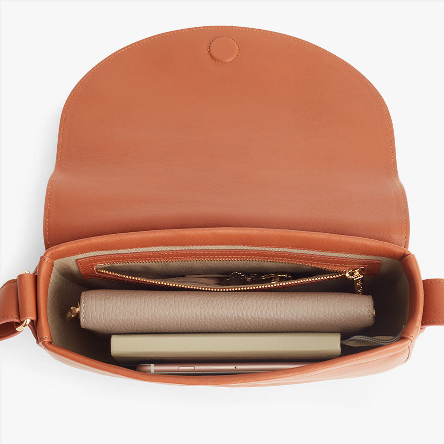 Open handbag with a wallet, notebook, and pen inside.