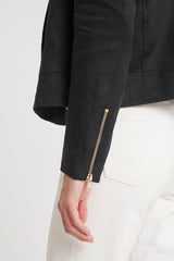 Woman's arm with a zipped sleeve detail of a jacket, partial view.